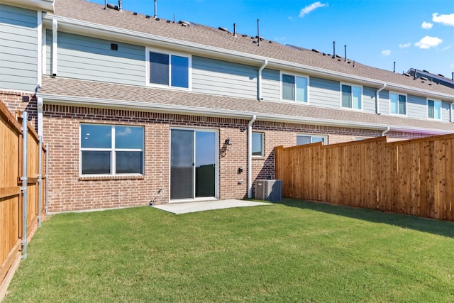 back of property featuring central AC unit, a lawn, and a patio area