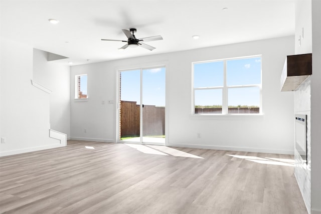 unfurnished living room with plenty of natural light, light hardwood / wood-style flooring, and ceiling fan