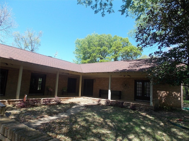 back of house featuring a lawn, french doors, and a patio