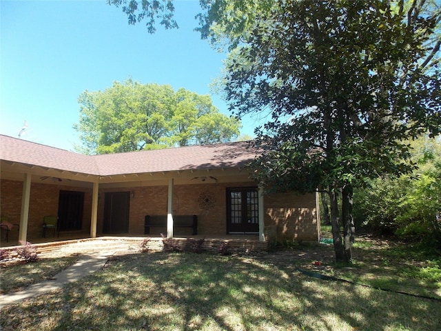 exterior space featuring a patio area, a lawn, and french doors