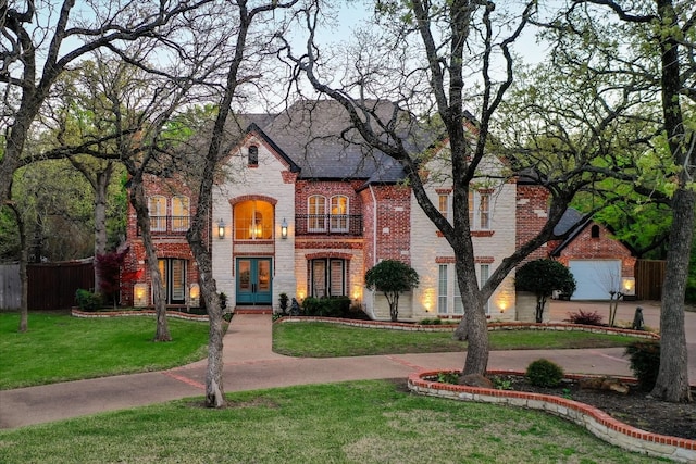 view of front facade featuring a balcony and a front yard