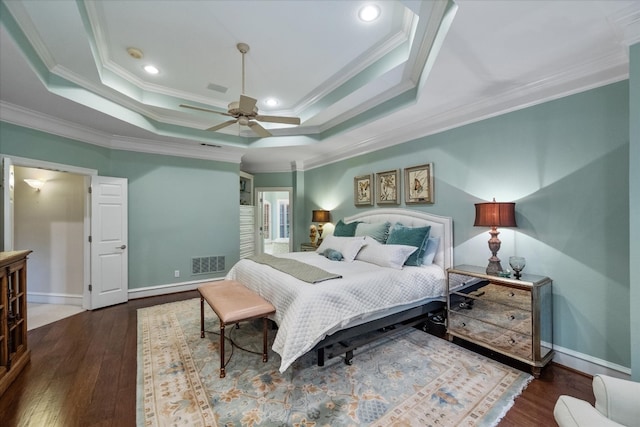 bedroom featuring crown molding, dark wood-type flooring, and a tray ceiling