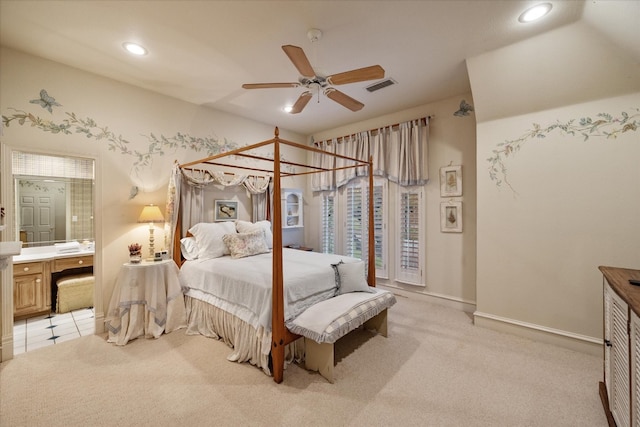 bedroom with light carpet, ensuite bath, and ceiling fan