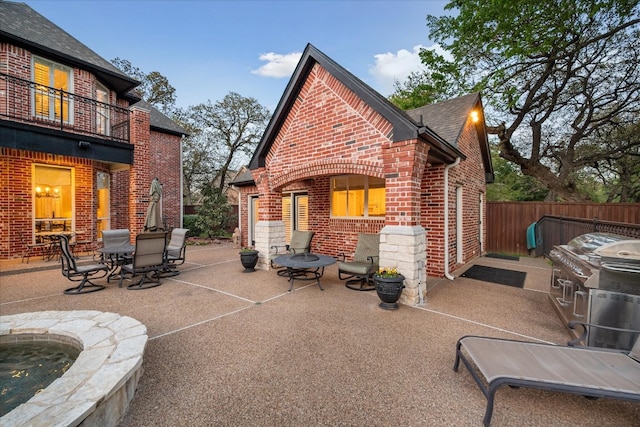 rear view of property with a balcony and a patio area