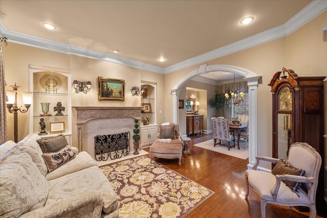 living room featuring a chandelier, dark wood-type flooring, and ornamental molding