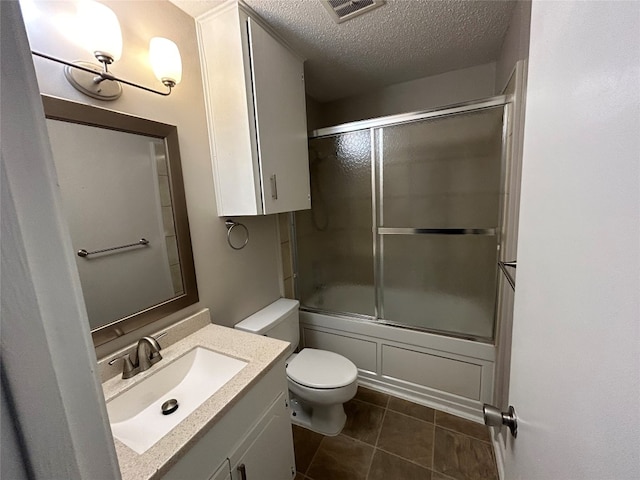 full bathroom with toilet, tile floors, shower / bath combination with glass door, a textured ceiling, and vanity