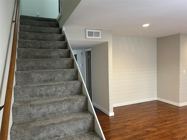 stairs featuring dark wood-type flooring