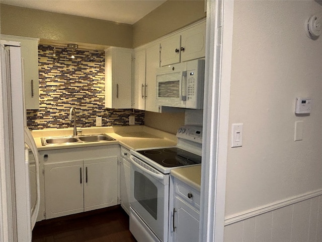 kitchen with backsplash, white appliances, white cabinetry, and sink