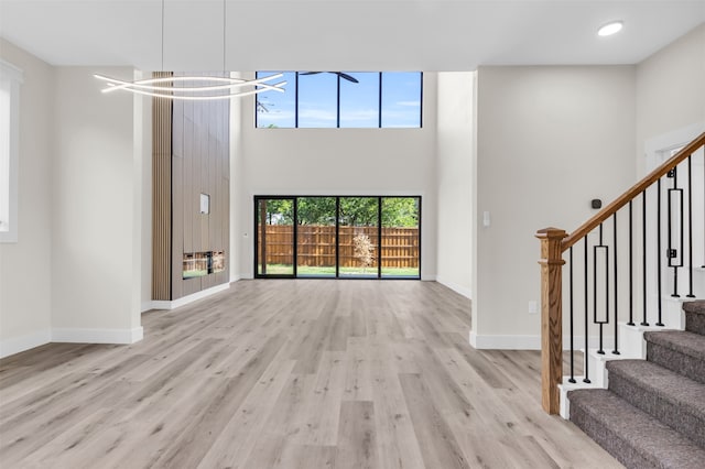 foyer entrance with light hardwood / wood-style flooring and a high ceiling