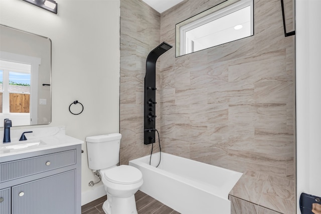 full bathroom featuring tiled shower / bath combo, toilet, and vanity