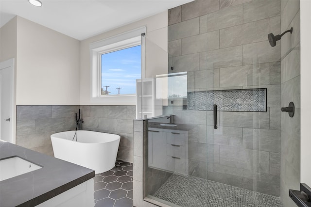 bathroom with vanity, walk in shower, tile walls, and tile patterned floors