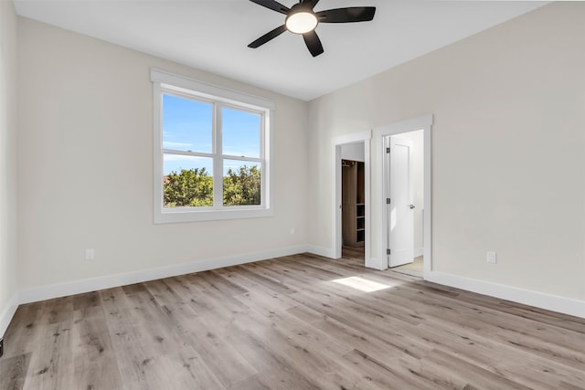 empty room with ceiling fan and light hardwood / wood-style floors