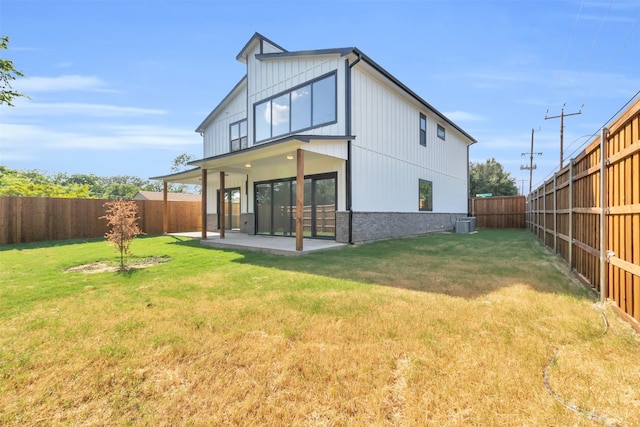 rear view of property featuring central air condition unit, a patio area, and a yard