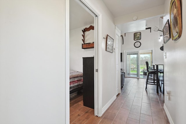 hallway featuring baseboards and wood tiled floor