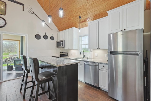 kitchen featuring stainless steel appliances, white cabinetry, sink, and light stone countertops