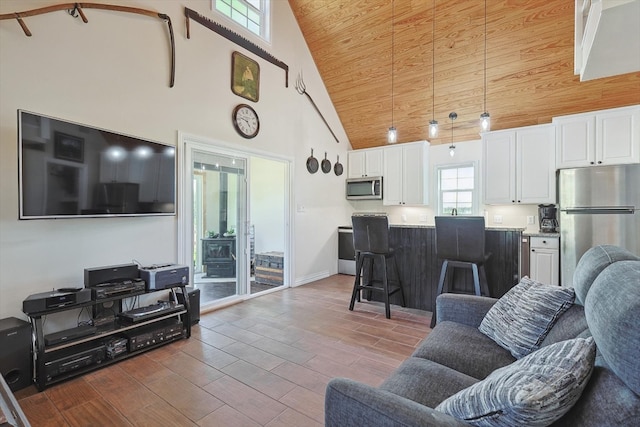 living room with high vaulted ceiling, wooden ceiling, baseboards, and wood finished floors