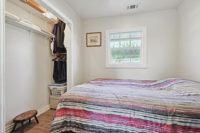 bedroom featuring baseboards, visible vents, and wood finished floors