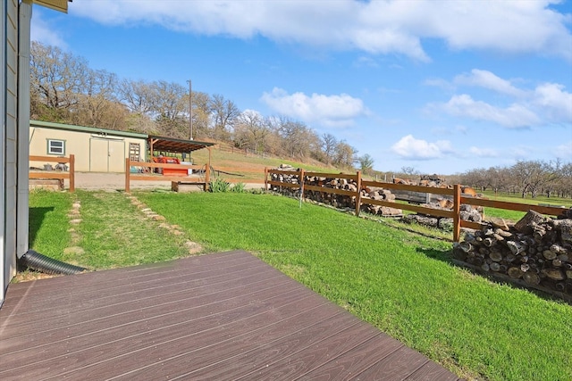 deck with fence, a lawn, and an outdoor structure