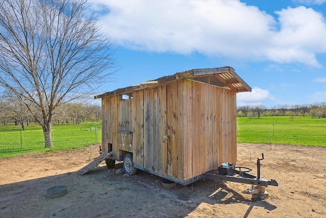 view of outdoor structure with a rural view and a lawn