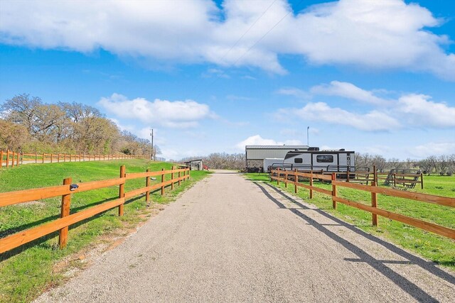 view of road with aphalt driveway and a rural view