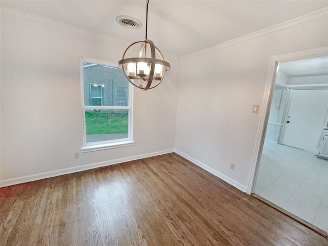 tiled spare room with a notable chandelier and ornamental molding