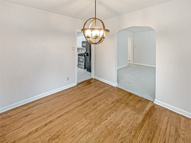 spare room with ornamental molding, a chandelier, and light carpet