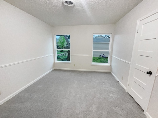 carpeted spare room featuring a textured ceiling