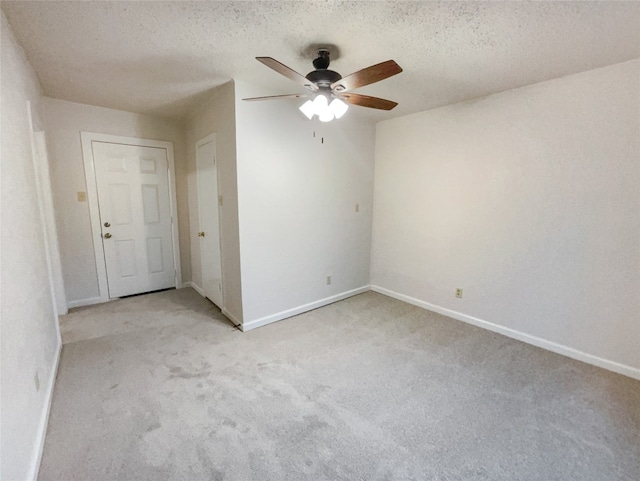 carpeted empty room featuring a textured ceiling and ceiling fan