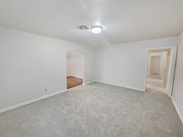 carpeted spare room featuring a textured ceiling