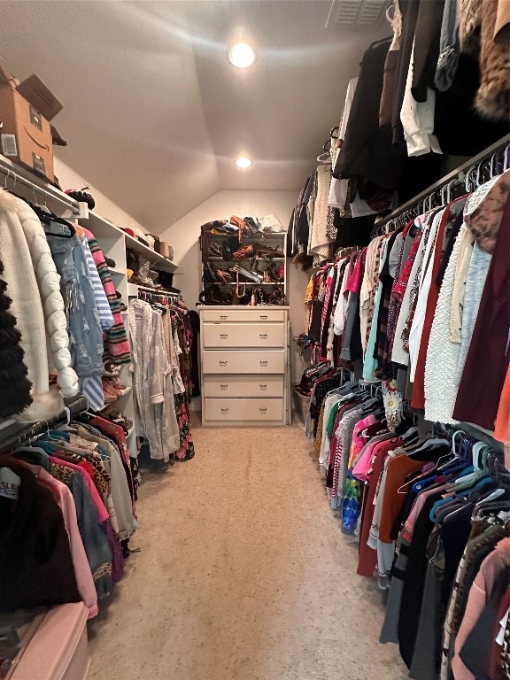 walk in closet featuring light carpet and vaulted ceiling