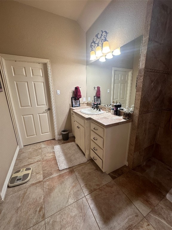 bathroom with lofted ceiling, tile floors, and large vanity