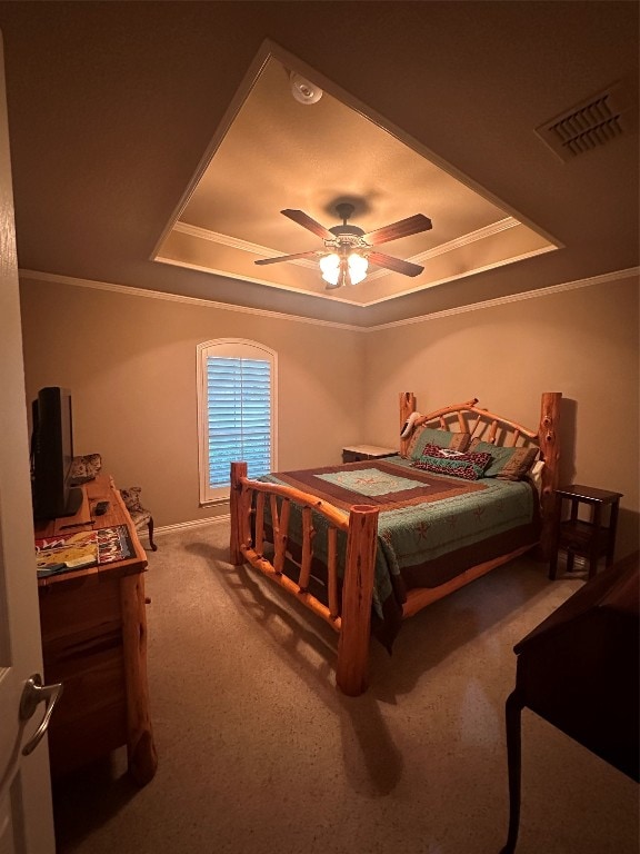 carpeted bedroom featuring ceiling fan, crown molding, and a tray ceiling