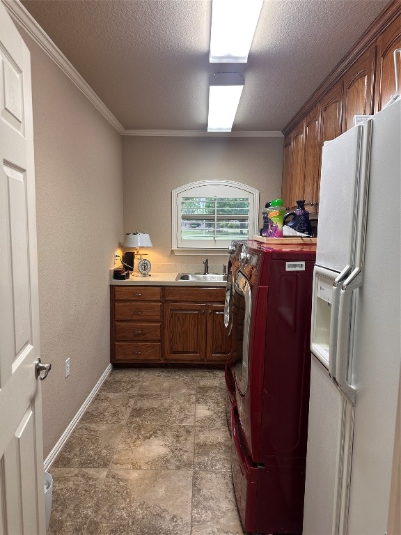 laundry area with light tile floors, crown molding, and a textured ceiling