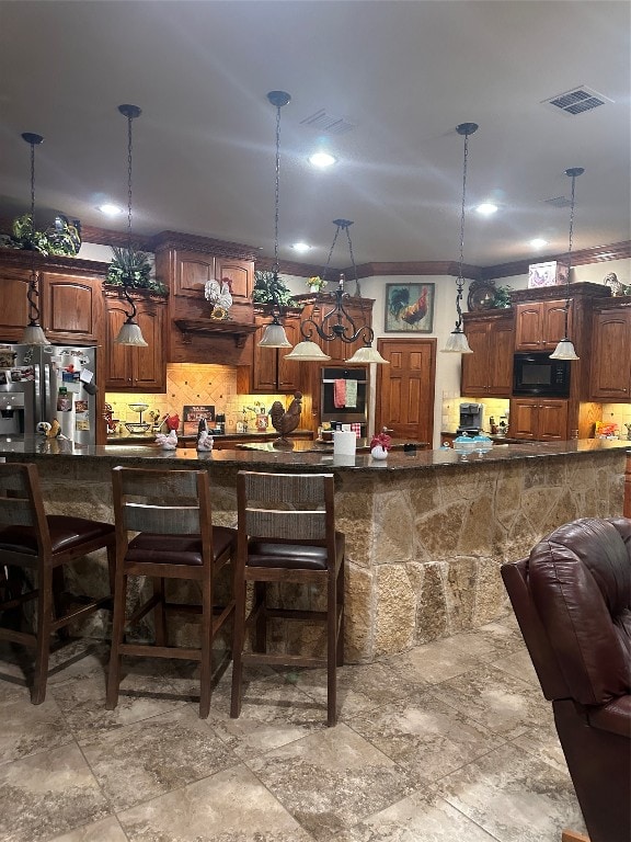 bar featuring black microwave, stainless steel refrigerator with ice dispenser, light tile floors, and decorative light fixtures