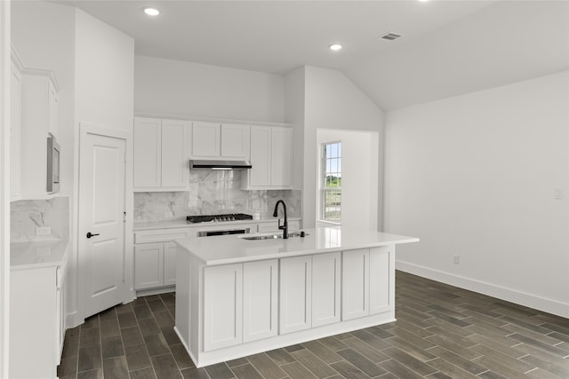 kitchen with white cabinetry, sink, and a center island with sink