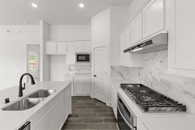 kitchen featuring built in microwave, sink, tasteful backsplash, wall oven, and white cabinets