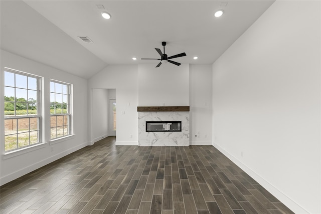 unfurnished living room featuring dark wood-type flooring, ceiling fan, a fireplace, and vaulted ceiling