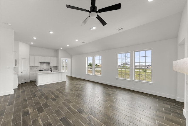 unfurnished living room featuring ceiling fan, lofted ceiling, and dark hardwood / wood-style flooring