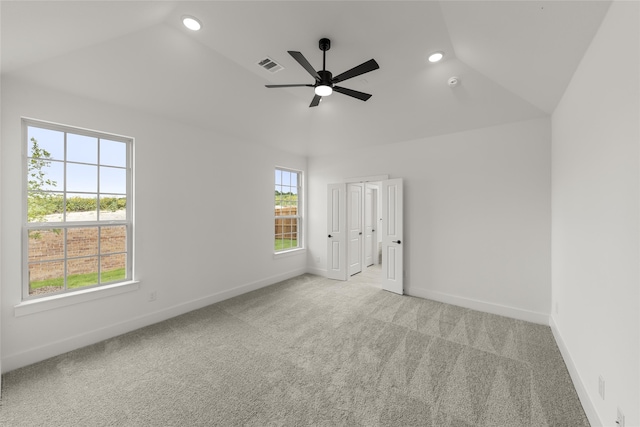 spare room featuring lofted ceiling, light carpet, and ceiling fan