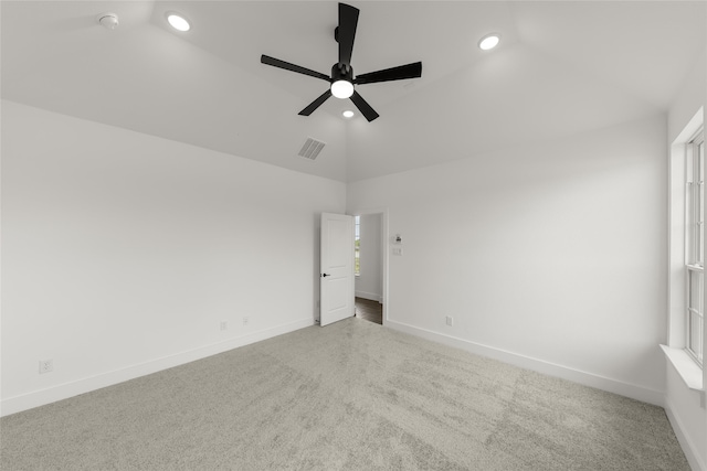 spare room featuring lofted ceiling, light colored carpet, and ceiling fan