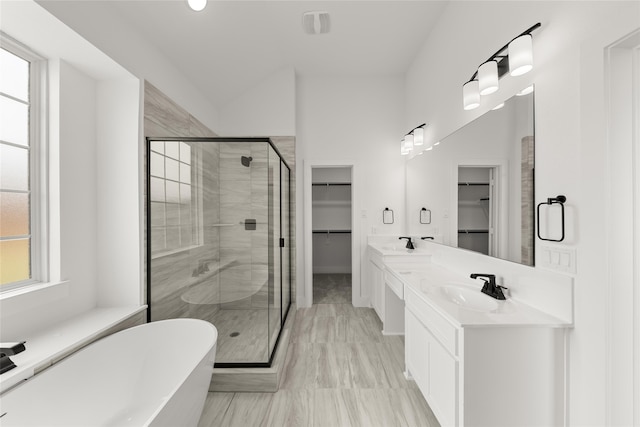 bathroom with vanity, a wealth of natural light, and plus walk in shower