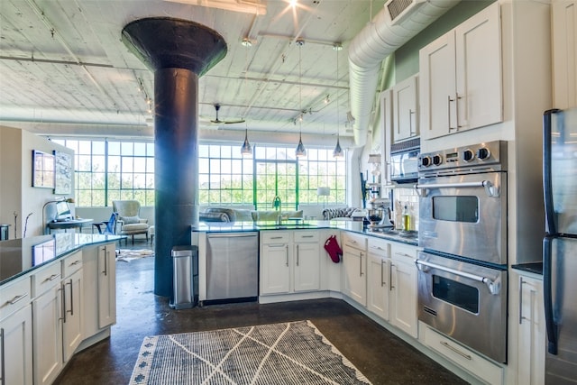 kitchen featuring hanging light fixtures, sink, appliances with stainless steel finishes, and white cabinetry