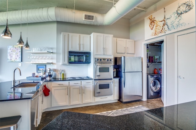 kitchen with pendant lighting, stainless steel appliances, sink, washer / clothes dryer, and white cabinets