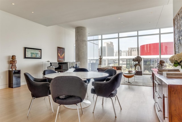 dining room with floor to ceiling windows and light hardwood / wood-style floors