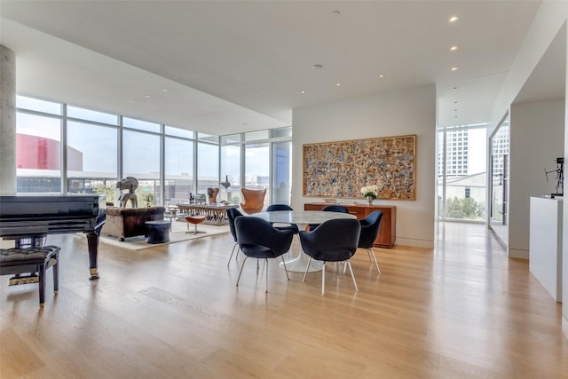 dining space featuring floor to ceiling windows, a wealth of natural light, and light hardwood / wood-style floors