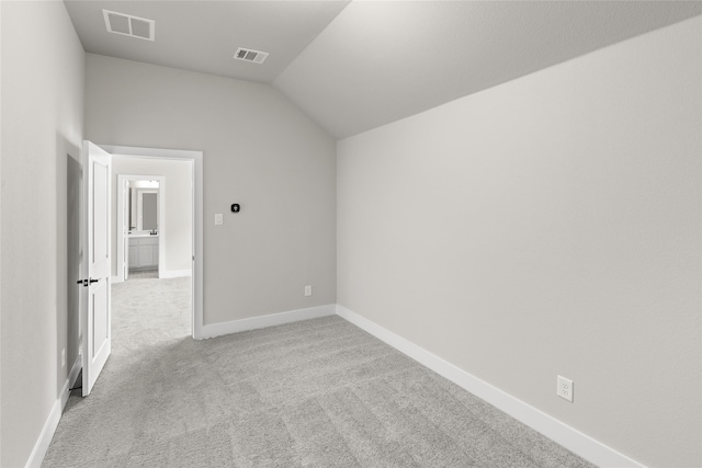 empty room with light carpet and vaulted ceiling