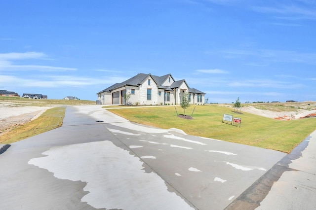 view of front of property featuring a garage and a front lawn