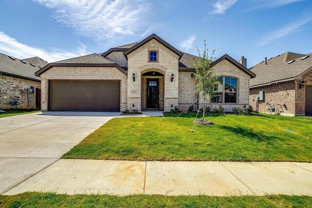 french country style house with a garage and a front yard