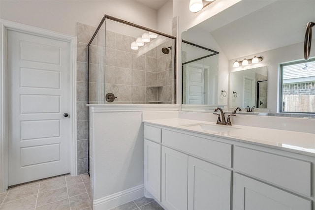 bathroom with vaulted ceiling, tile patterned flooring, a shower with door, and vanity