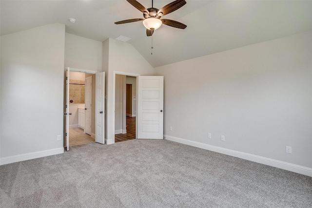 unfurnished bedroom with light carpet, baseboards, and lofted ceiling